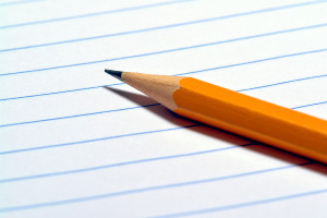 Sharp pencil on a blank ruled notebook page